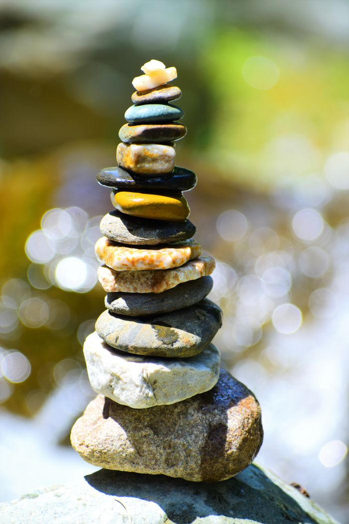 Close-up of a balanced stone stack against a natural bokeh background.